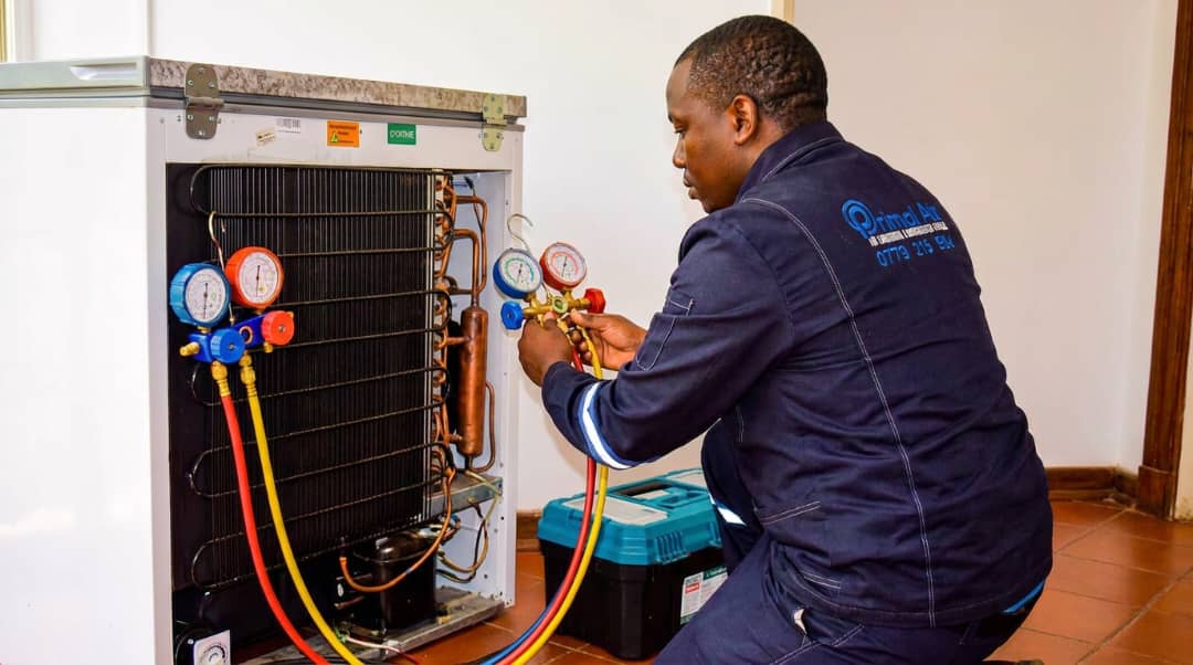 Primal Air technician regassing a fridge with manifold gauges in Harare